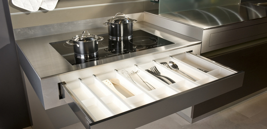 The worktop can be moved to any height at the push of a button, and the handle-less drawer with push function is directly accessible below this.